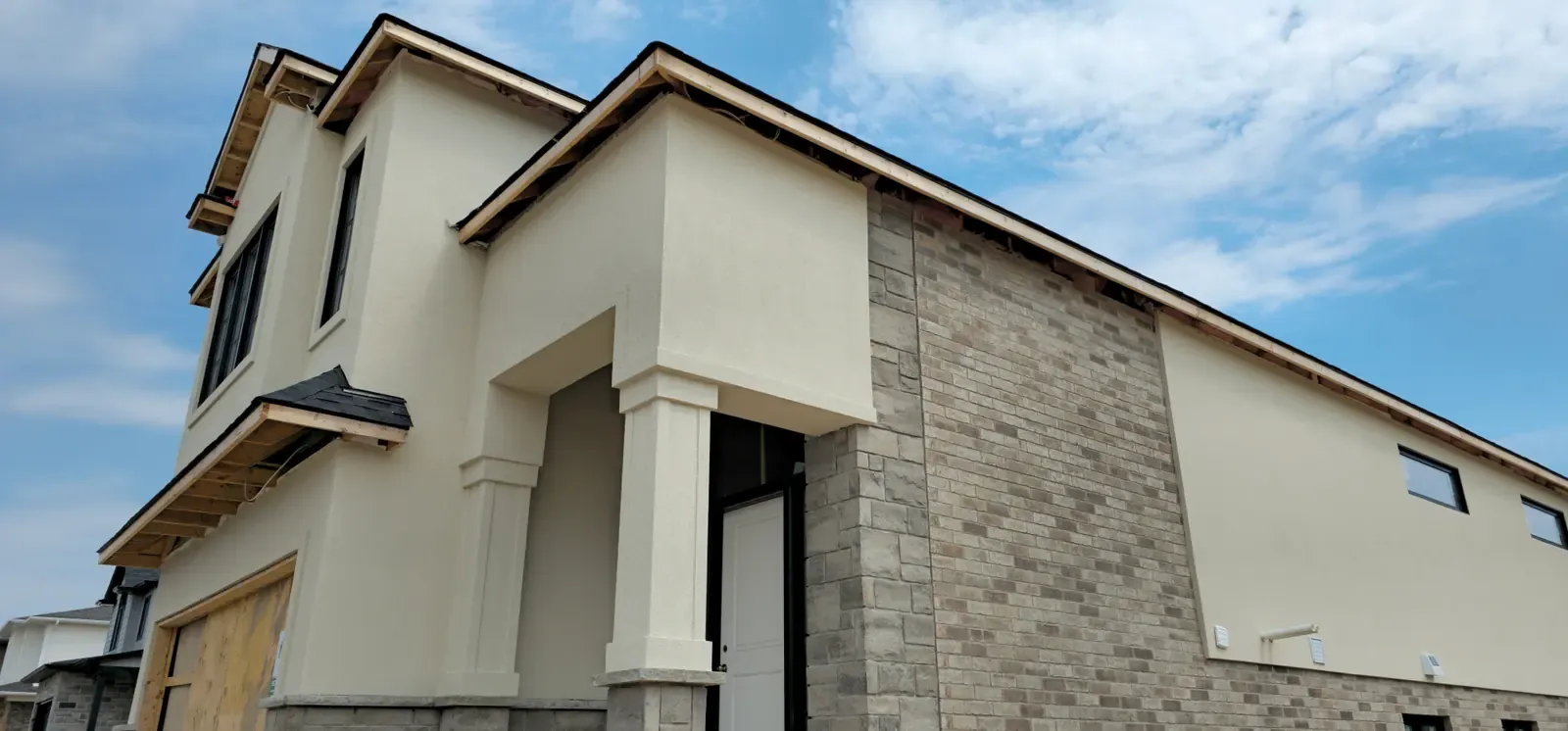 Classical stucco residence with columns and stone base in the Niagara Region