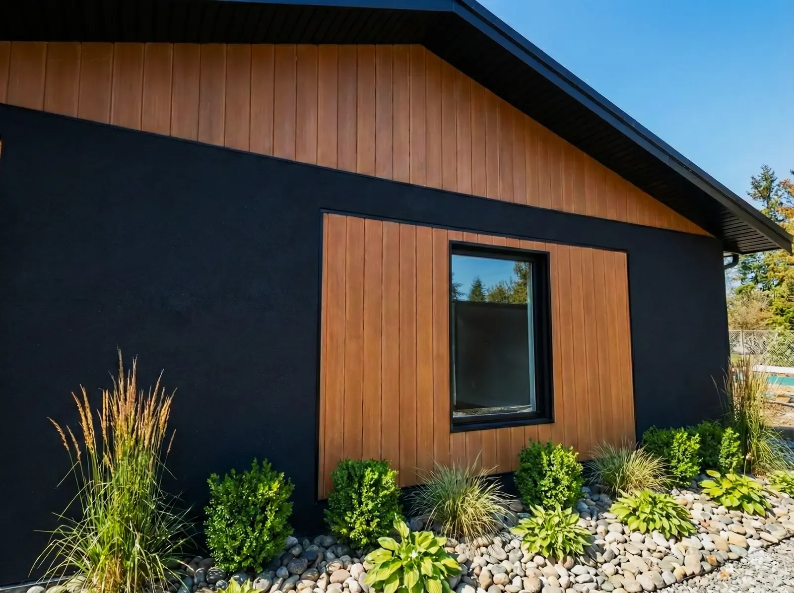 Modern home in Lincoln with dark stucco and warm wood cladding
