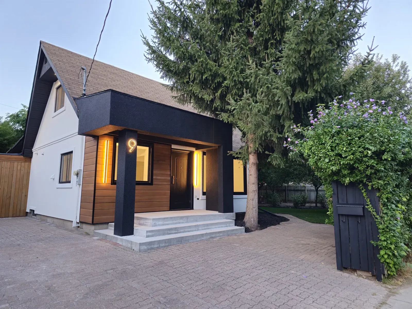 Renovated front entry with dark stucco and wood accents