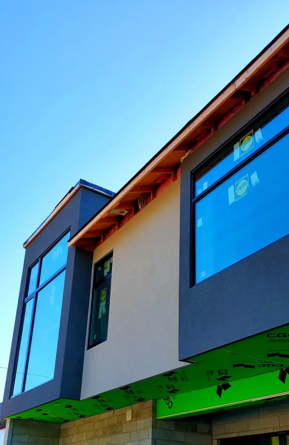 Smooth white stucco on a modern home with large dark-framed windows
